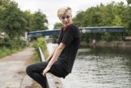 Young woman sitting on railin...