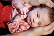 Two-week-old baby with hands ...