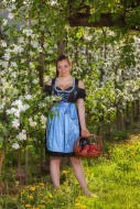 Woman in dirndl stands beside...