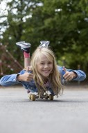 Mdchen (10) liegt auf Skateb...