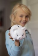 Girl (7) with piggy bank, Kie...