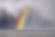 Colourful rainbow over sea wa...