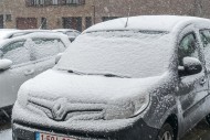 Parked cars covered in snow d...