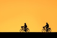Cycling elderly couple wearin...